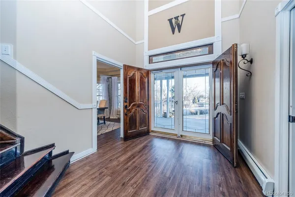 a view of a hallway to a livingroom with wooden floor and furniture