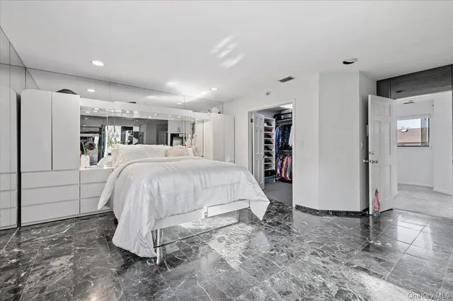 a spacious bedroom with a bed and a refrigerator