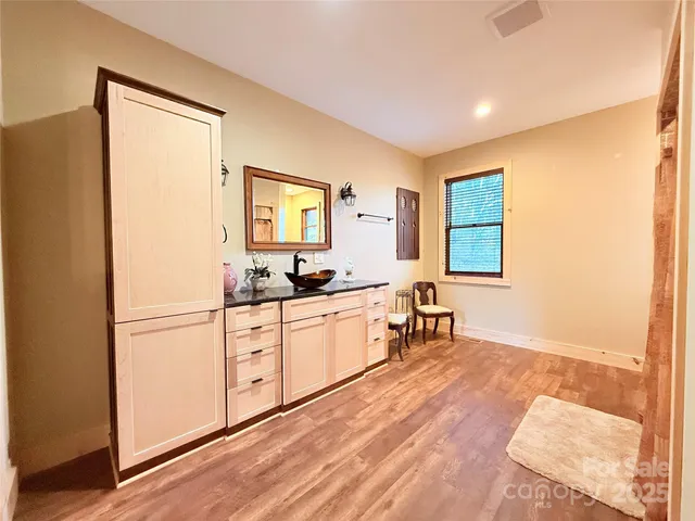 a view of a livingroom with wooden floor and a refrigerator