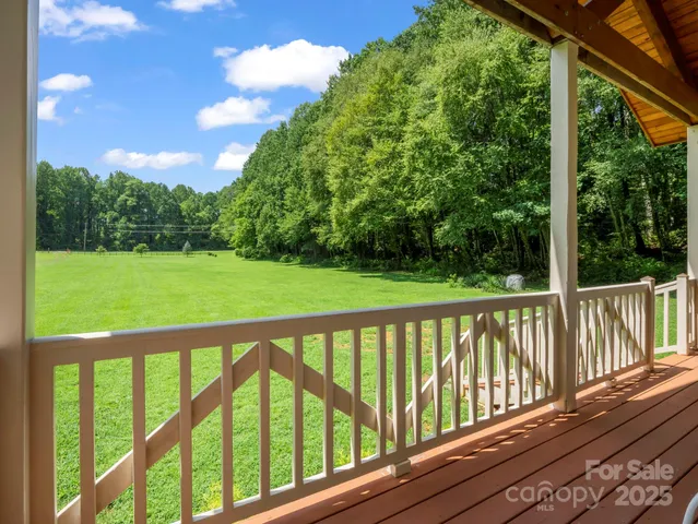 a view of a chairs and table on the wooden roof deck