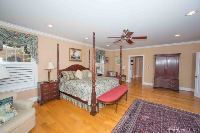 87 Eagle Point Road Lancaster, VA 22503 - Photo 15 of 36 a bed room with a bed and a chandelier
