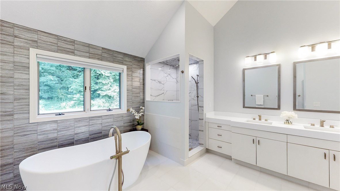 3700 Chagrin River Road Chagrin Falls, OH 44022 - Photo 13 of 43 Bathroom with tile walls, lofted ceiling, tile patterned floors, separate shower and tub, and dual bowl vanity