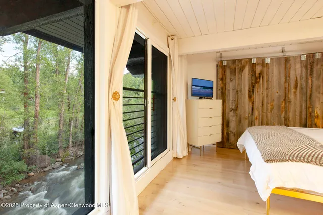 a living room with a flat screen tv and a walk in closet
