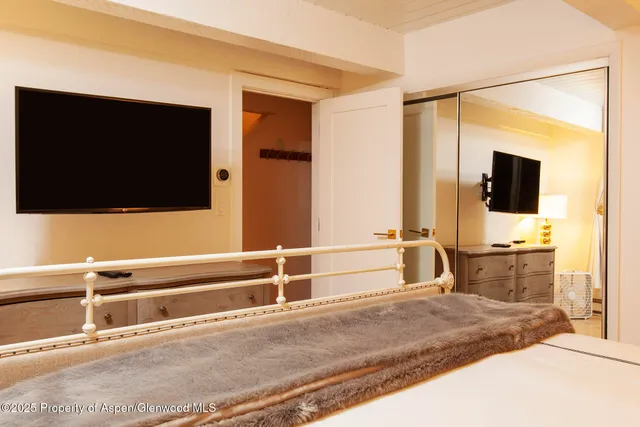 a bedroom with a bed and a flat screen tv