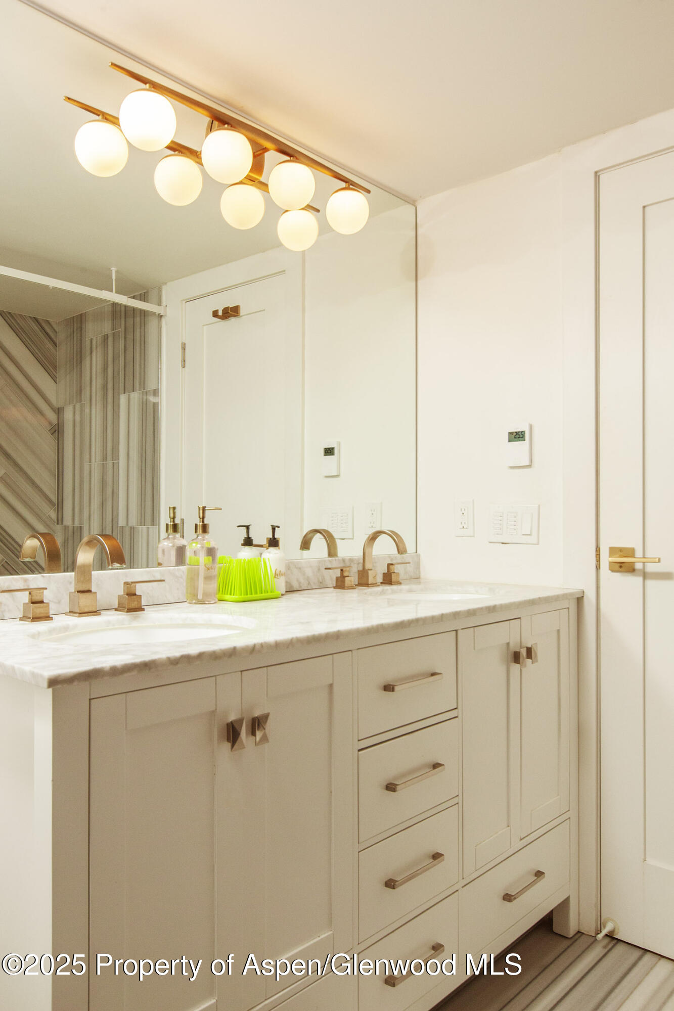 1039 East Cooper Avenue, Unit 16A Aspen, CO 81611 - Photo 25 of 37 a bathroom with a sink and mirror