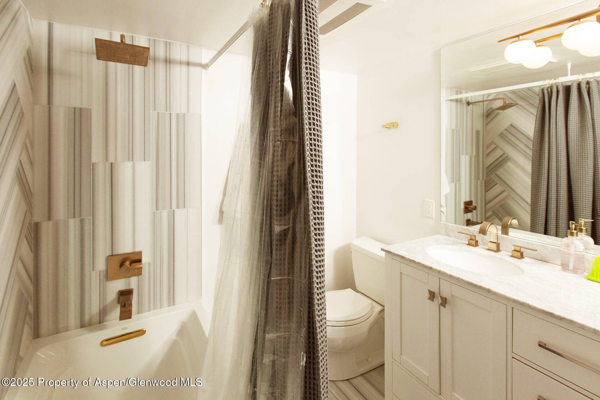 1039 East Cooper Avenue, Unit 16A Aspen, CO 81611 - Photo 26 of 37 a bathroom with a sink a toilet and shower curtain