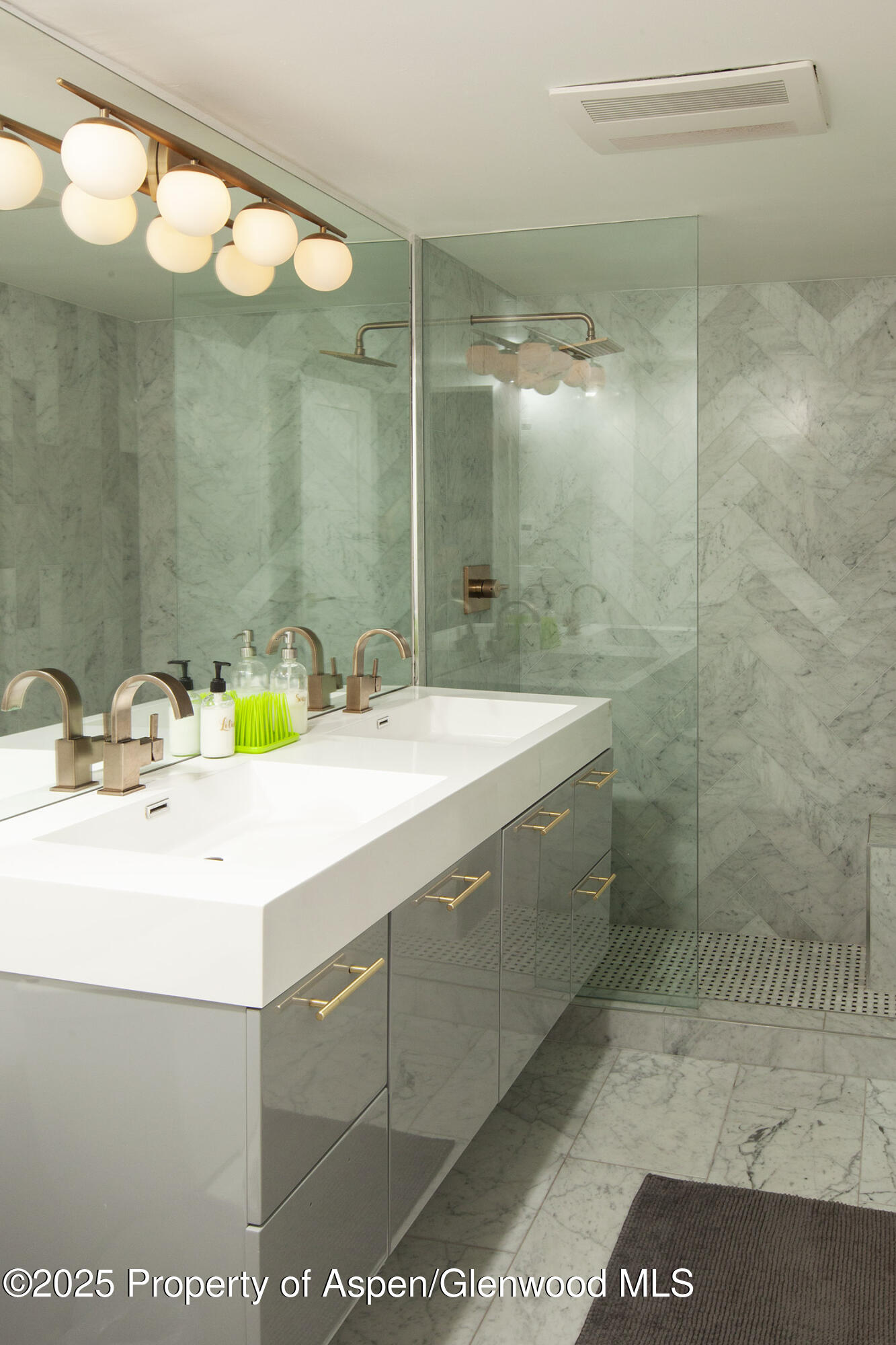 1039 East Cooper Avenue, Unit 16A Aspen, CO 81611 - Photo 28 of 37 a bathroom with a sink a mirror and a shower