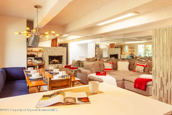a living room with furniture a fireplace and a chandelier