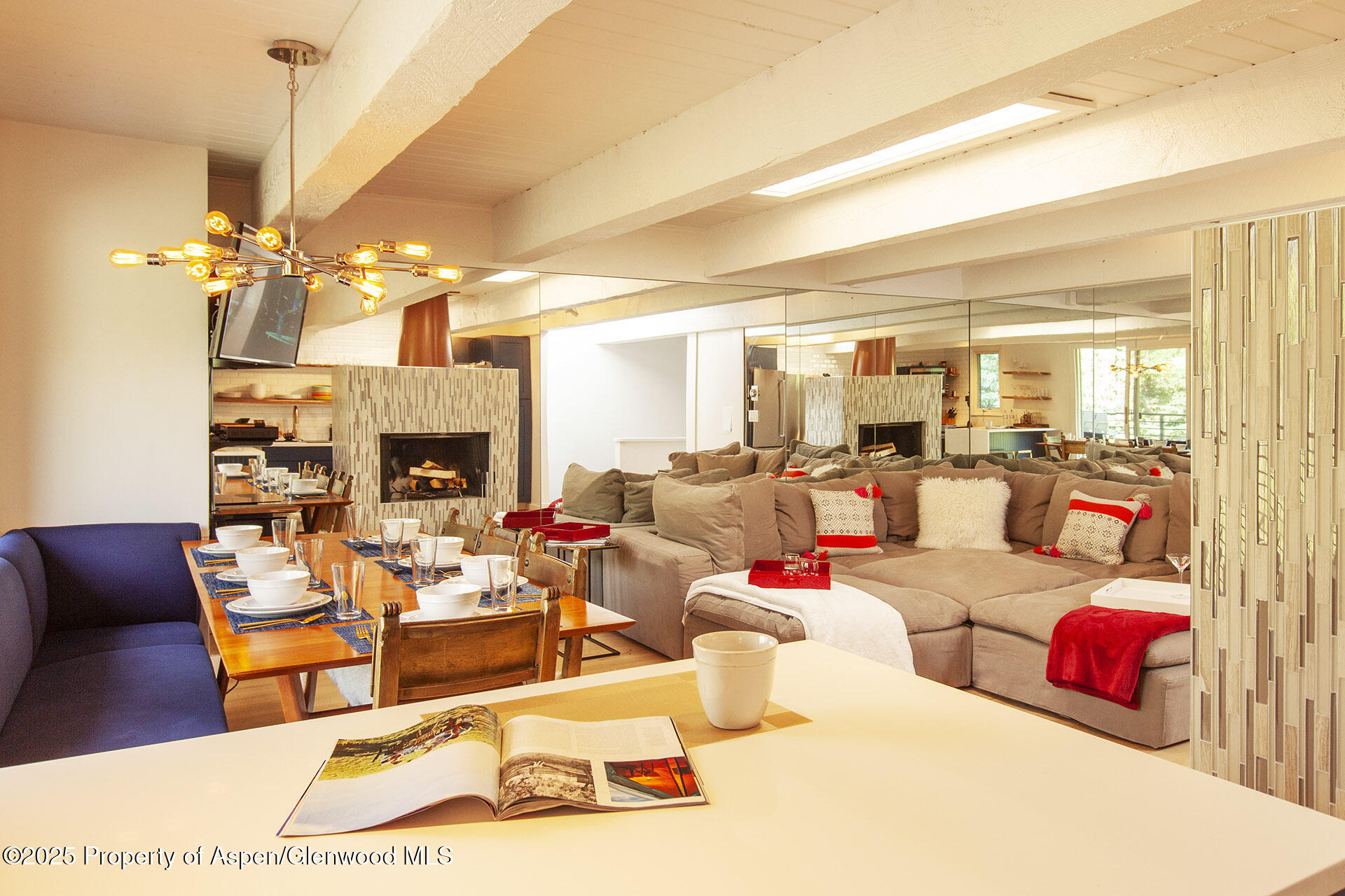 1039 East Cooper Avenue, Unit 16A Aspen, CO 81611 - Photo 5 of 37 a living room with furniture a fireplace and a chandelier