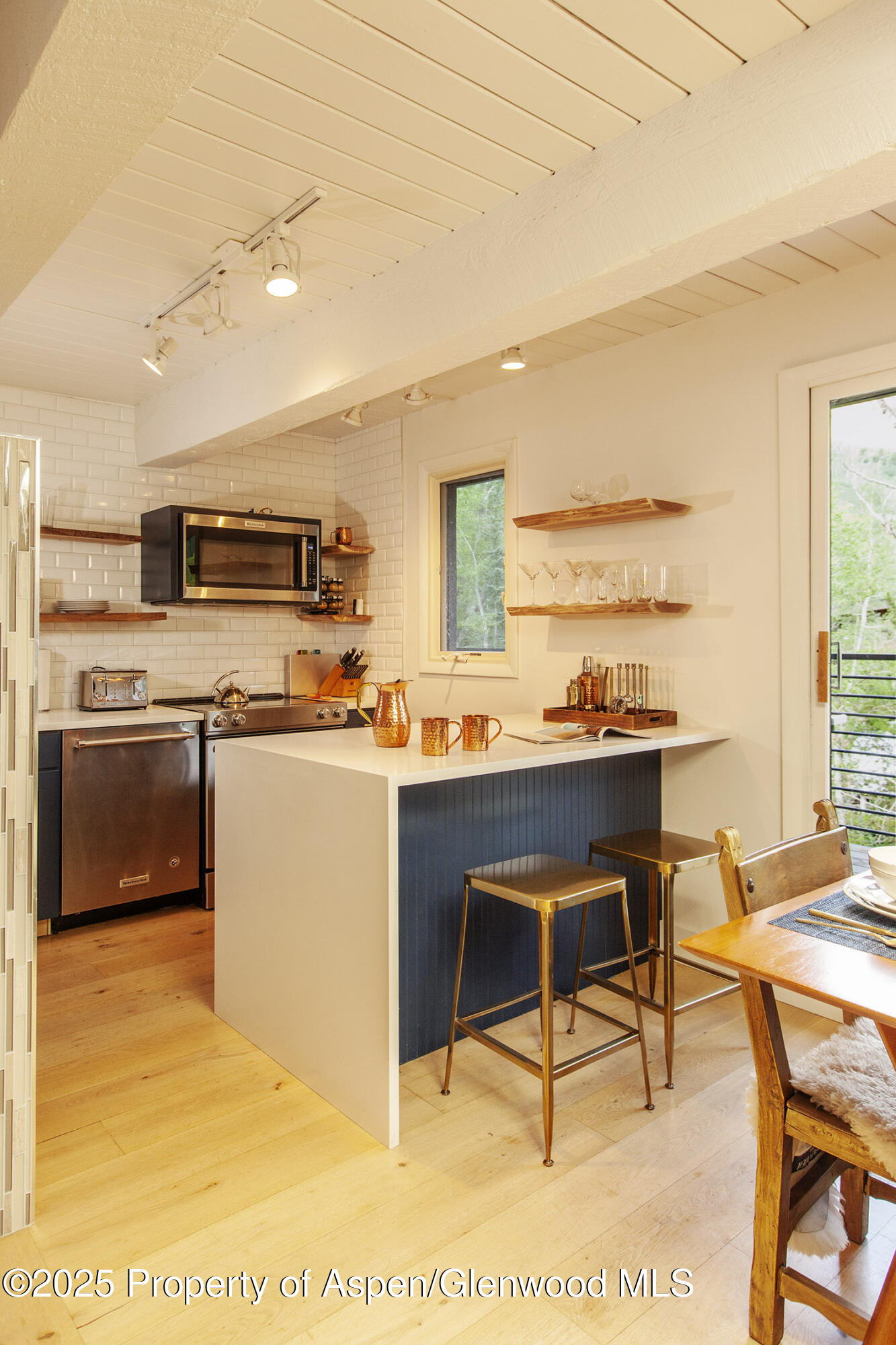 1039 East Cooper Avenue, Unit 16A Aspen, CO 81611 - Photo 7 of 37 a kitchen with stainless steel appliances kitchen island granite countertop a sink and cabinets