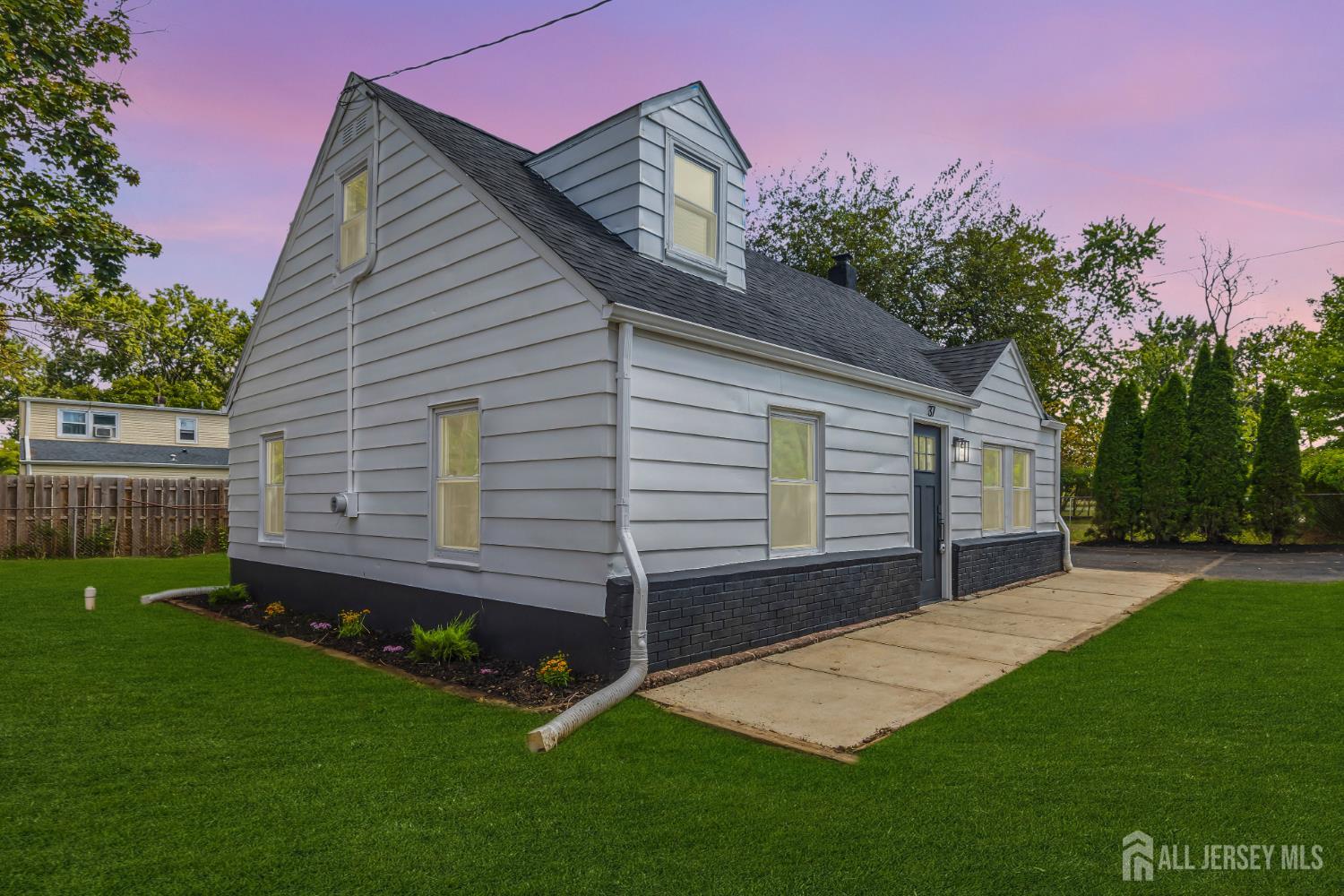 a front view of a house with a yard and deck