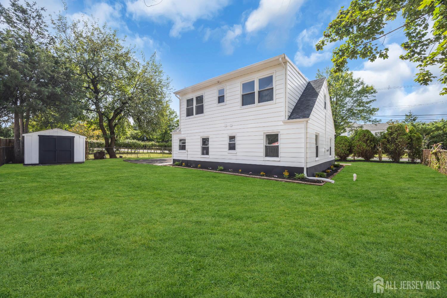 37 North Randolphville Road Piscataway, NJ 08854 - Photo 27 of 31 a view of a white house in front of a big yard with large trees