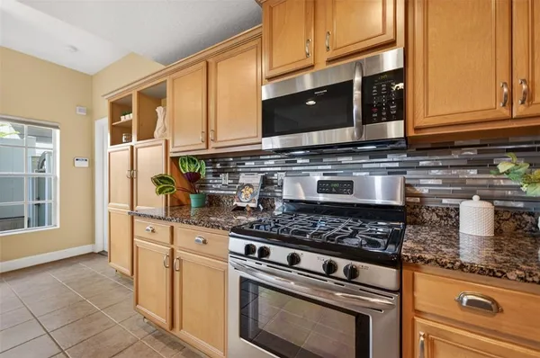 a kitchen with stainless steel appliances granite countertop a stove and a microwave