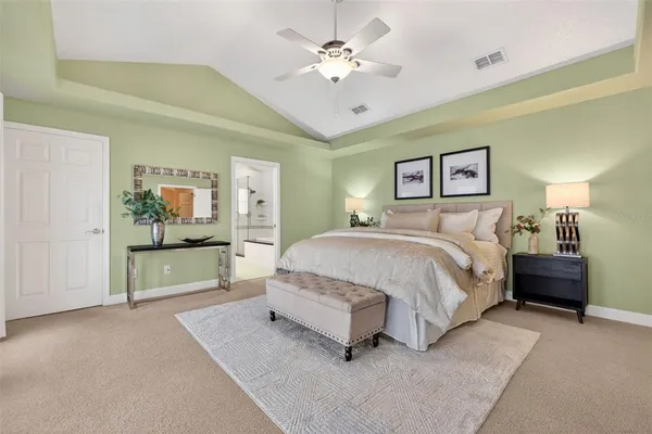 a spacious bedroom with a large bed a lamp on table and a window