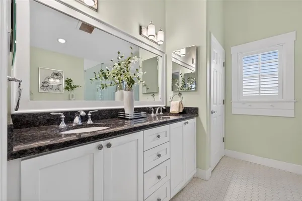 a bathroom with double sink and a mirror