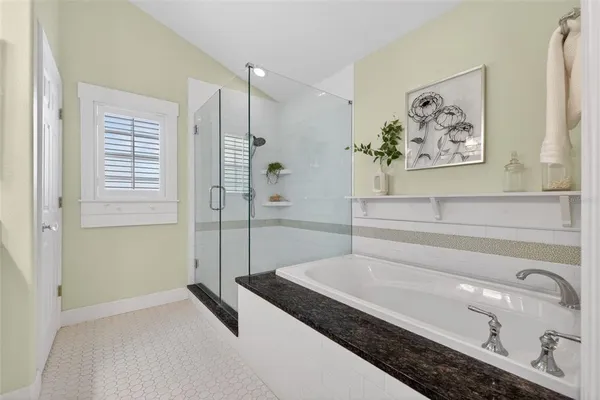 a bathroom with a tub a sink and glass door shower
