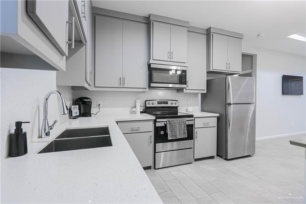 913 West Sunset Valley Street Mission, TX 78573 - Photo 14 of 24 a kitchen with stainless steel appliances a refrigerator stove microwave and sink