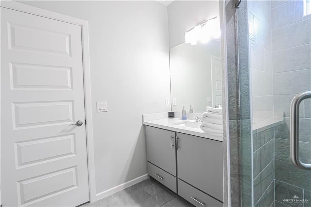 913 West Sunset Valley Street Mission, TX 78573 - Photo 19 of 24 a bathroom with a double vanity sink and mirror