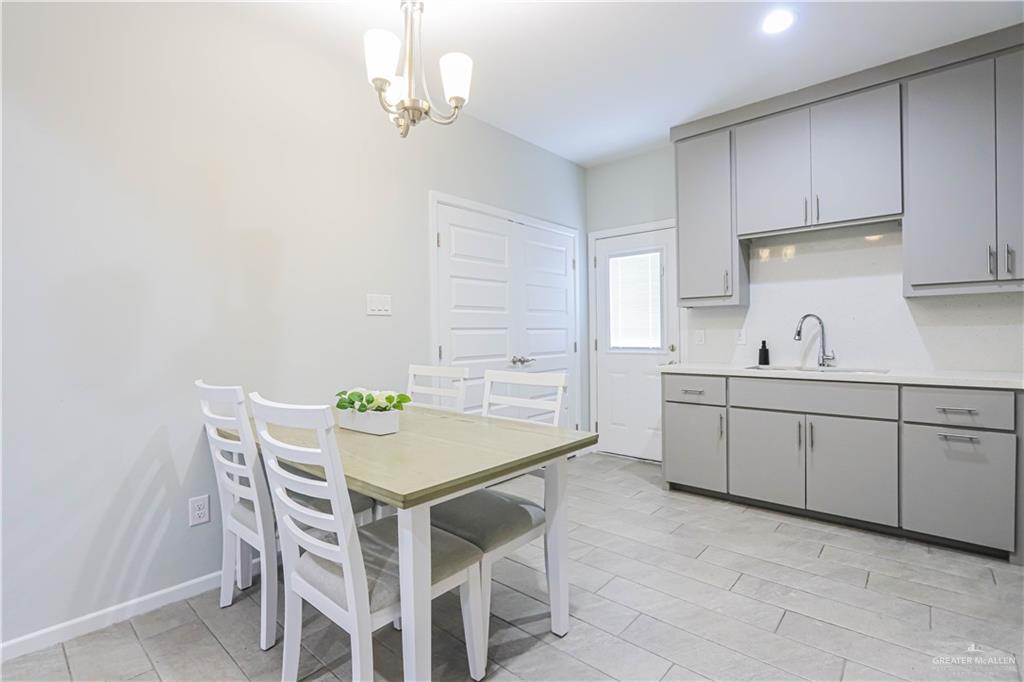 913 West Sunset Valley Street Mission, TX 78573 - Photo 10 of 24 a kitchen with a dining table chairs and cabinets