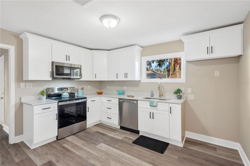 5226 Lime Avenue Seffner, FL 33584 - Photo 2 of 20 a kitchen with stainless steel appliances granite countertop a stove a sink and a microwave