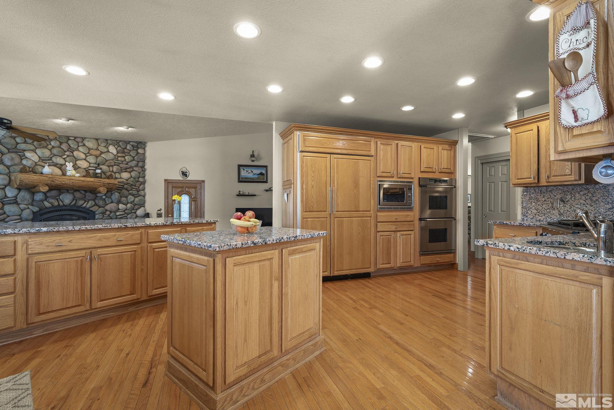 480 Duck Hill Road Washoe Valley, NV 89704 - Photo 16 of 46 a kitchen with granite countertop a refrigerator and a stove top oven