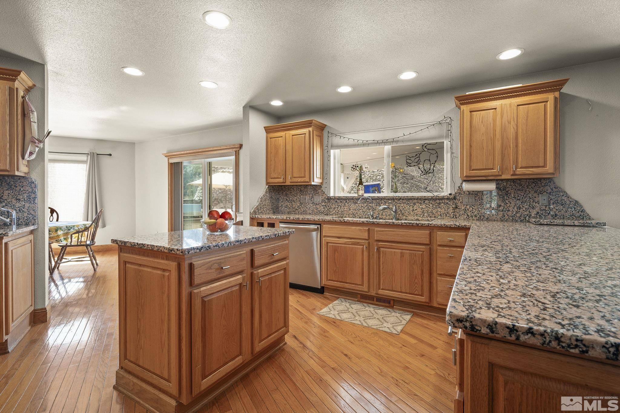 480 Duck Hill Road Washoe Valley, NV 89704 - Photo 17 of 46 a kitchen with granite countertop a sink stove and cabinets