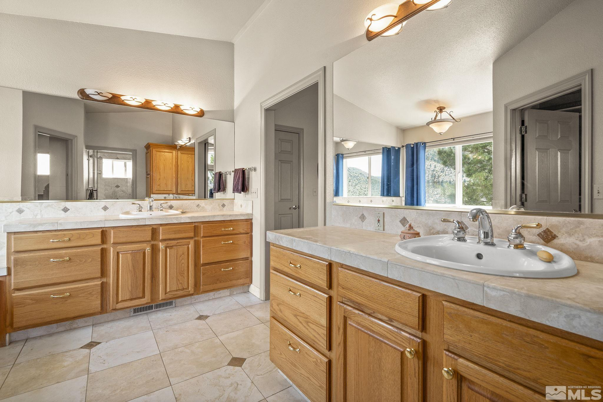 480 Duck Hill Road Washoe Valley, NV 89704 - Photo 20 of 46 a spacious bathroom with a granite countertop sink mirror and double