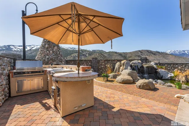 a view of a patio with a table and chairs under an umbrella