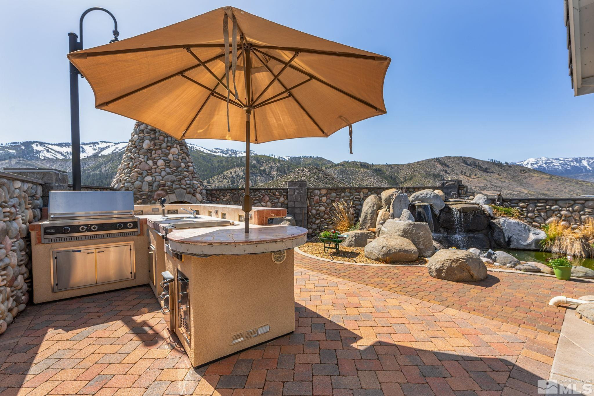 480 Duck Hill Road Washoe Valley, NV 89704 - Photo 32 of 46 a view of a patio with a table and chairs under an umbrella