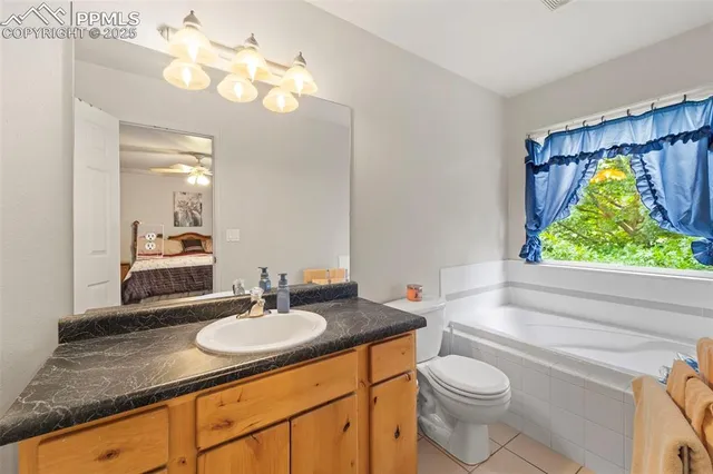 a bathroom with a granite countertop sink a toilet and bathtub