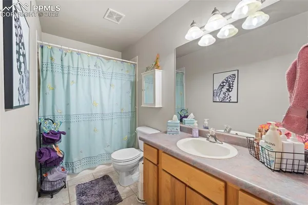 a bathroom with a sink vanity granite and toilet