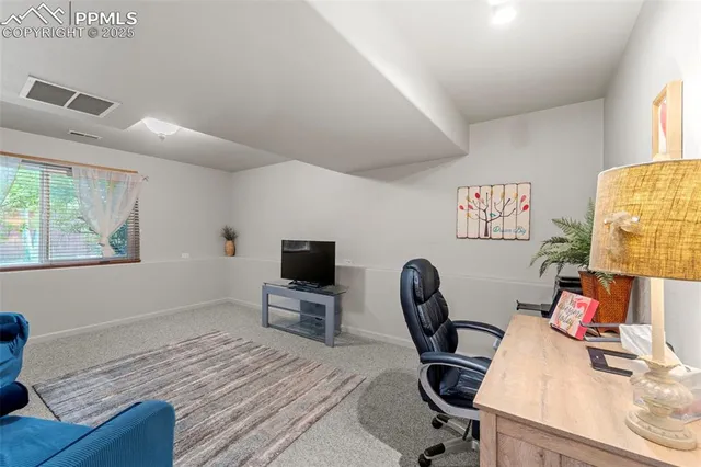 a view of a workspace with furniture and a window