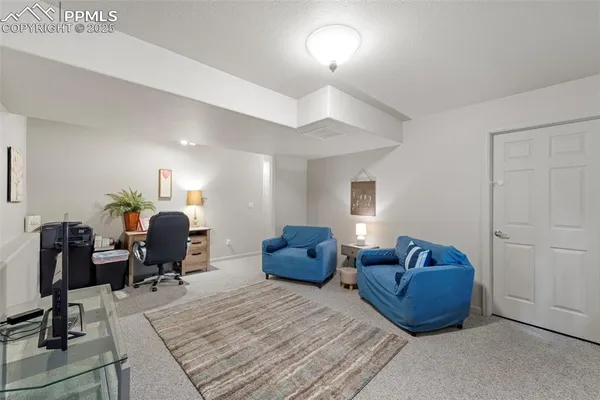 a living room with furniture a lamp and wooden floor