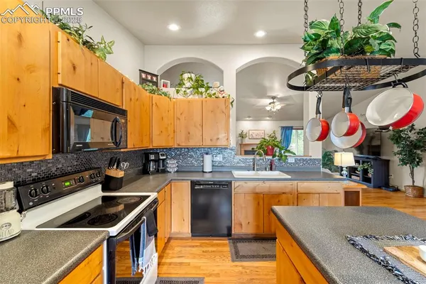a kitchen that has a lot of cabinets and stainless steel appliances