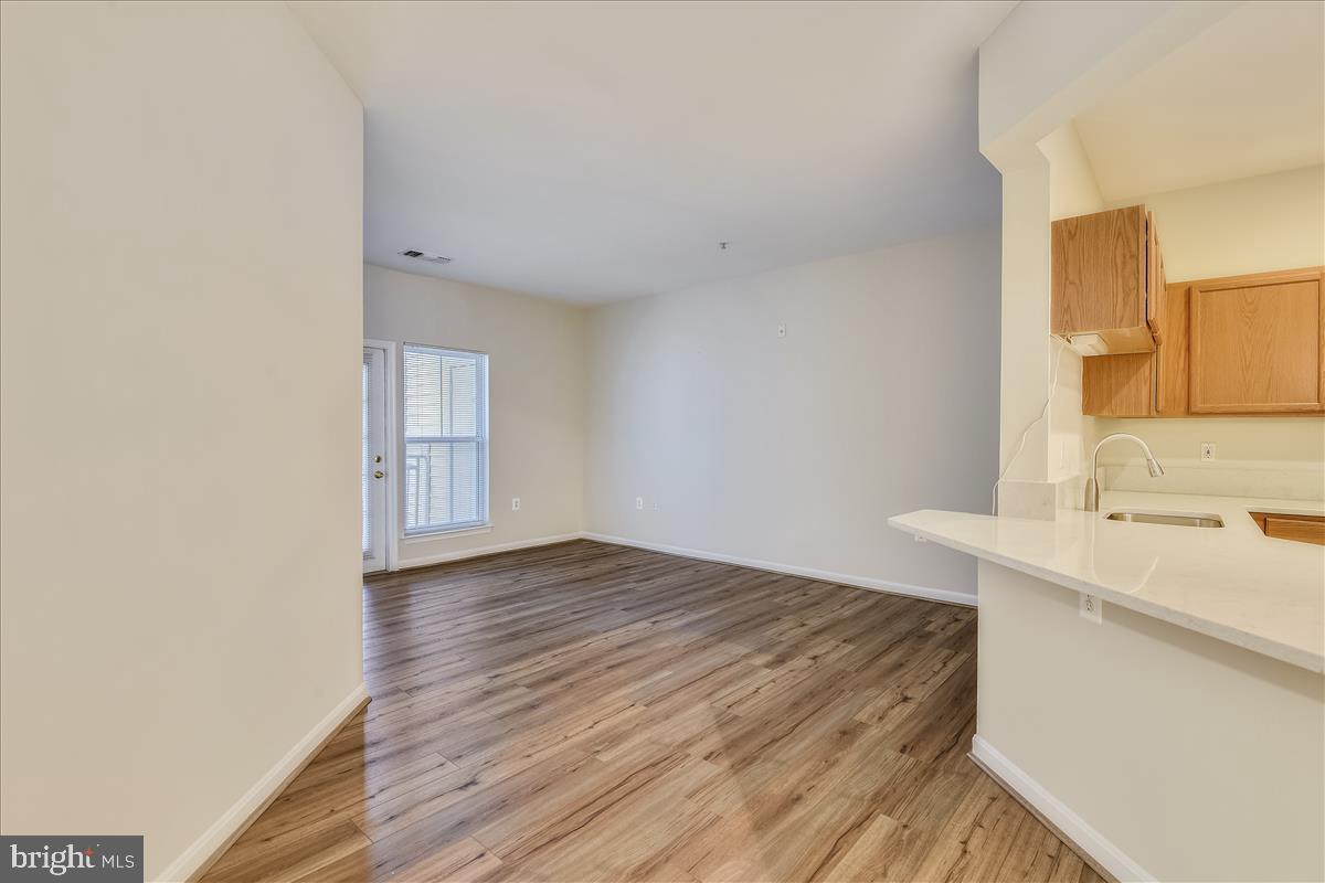 2931 Deer Hollow Way, Unit 102 Fairfax, VA 22031 - Photo 14 of 86 a view of a kitchen with a sink and dishwasher with wooden floor