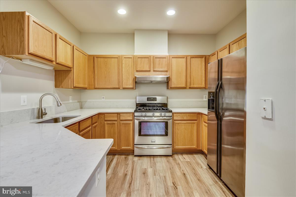 2931 Deer Hollow Way, Unit 102 Fairfax, VA 22031 - Photo 17 of 86 a kitchen with stainless steel appliances granite countertop a sink stove and refrigerator