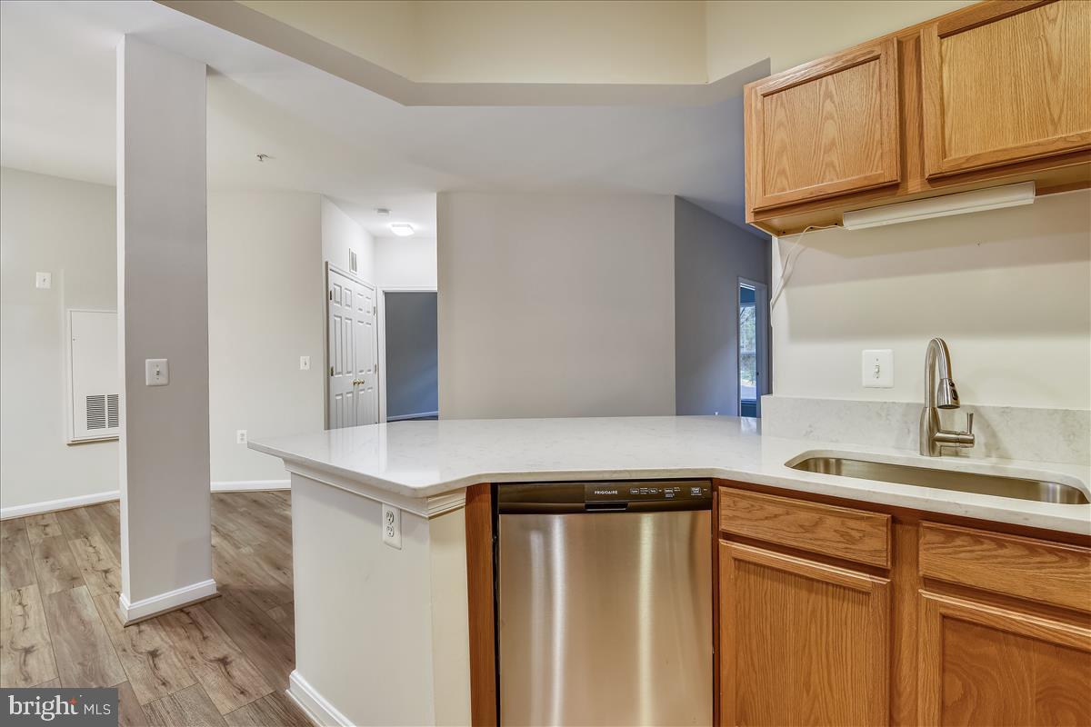 2931 Deer Hollow Way, Unit 102 Fairfax, VA 22031 - Photo 18 of 86 a kitchen with stainless steel appliances granite countertop a sink and a refrigerator