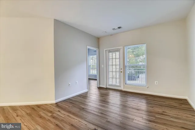 a view of an empty room with wooden floor