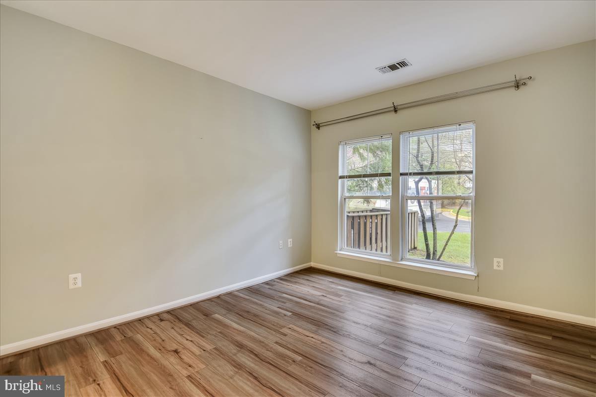 2931 Deer Hollow Way, Unit 102 Fairfax, VA 22031 - Photo 27 of 86 an empty room with wooden floor and windows