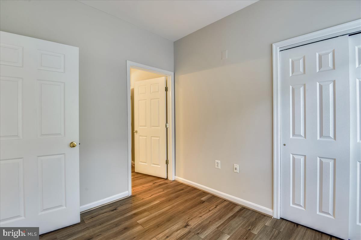 2931 Deer Hollow Way, Unit 102 Fairfax, VA 22031 - Photo 9 of 86 a view of an empty room with wooden floor