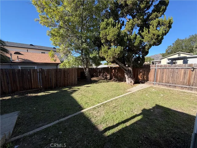 a view of a yard with wooden fence