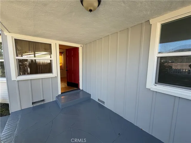a view of a hallway to a livingroom with furniture and windows