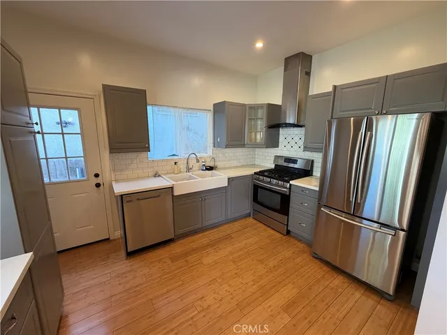 a kitchen with a refrigerator sink and wooden floor