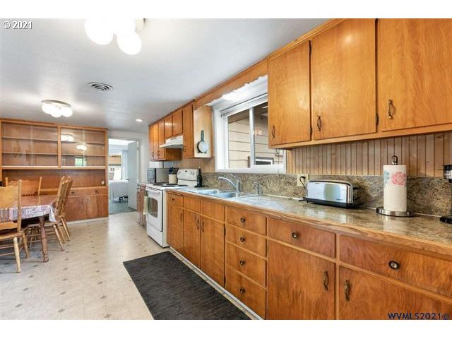 2455 G Street Springfield, OR 97477 - Photo 21 of 32 a kitchen with granite countertop a sink window and cabinets