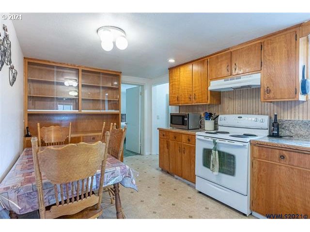 2455 G Street Springfield, OR 97477 - Photo 28 of 32 a kitchen with granite countertop a stove a sink and a microwave
