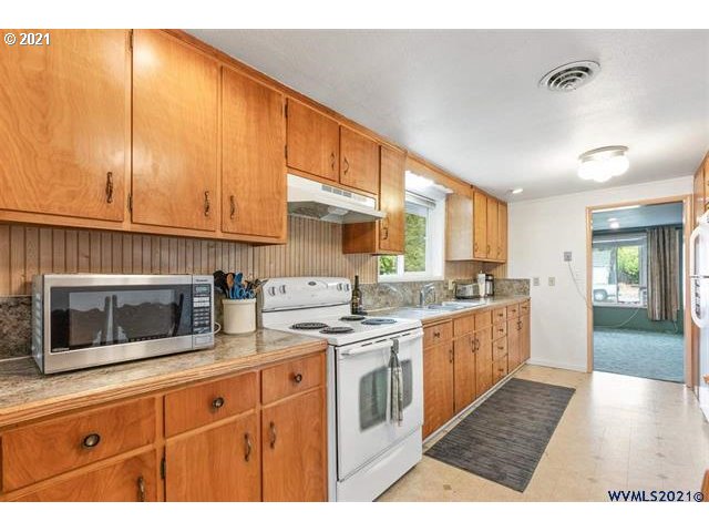 2455 G Street Springfield, OR 97477 - Photo 30 of 32 a kitchen with stainless steel appliances granite countertop a stove a sink and a microwave