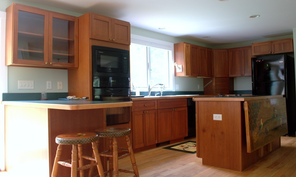 15 Ed Clark Road Hubbardston, MA 01452 - Photo 4 of 19 a kitchen with stainless steel appliances granite countertop a refrigerator a sink dishwasher a stove a dining table and chairs with wooden floor