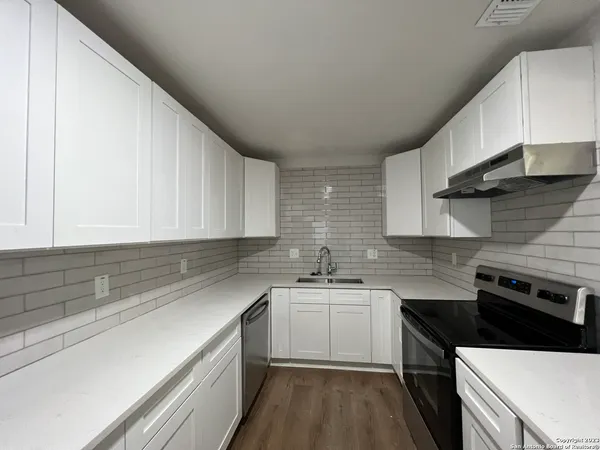 a kitchen with a sink stove and cabinets