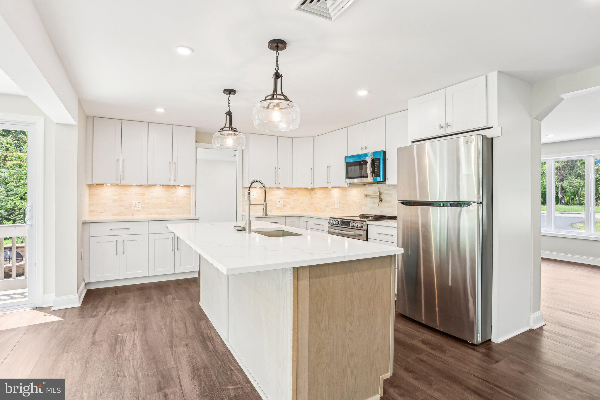 302 Fenwick Road Pilesgrove, NJ 08098 - Photo 17 of 51 a kitchen with kitchen island a sink refrigerator and wooden floor