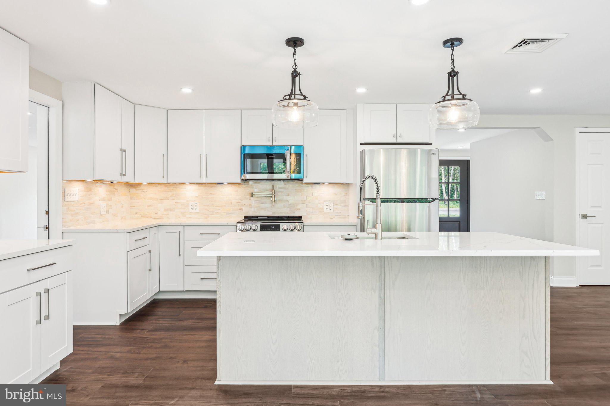 302 Fenwick Road Pilesgrove, NJ 08098 - Photo 21 of 51 a kitchen with stainless steel appliances kitchen island a sink a stove a refrigerator and white cabinets